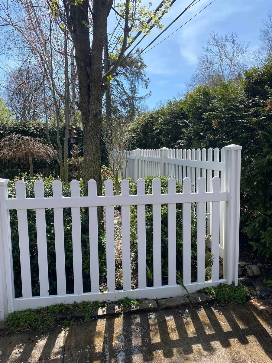 White vinyl picket fence after soft washing, clean and free of algae