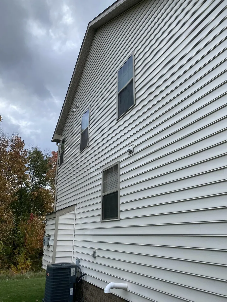 Two-story house with vinyl siding after house washing, clean and streak-free